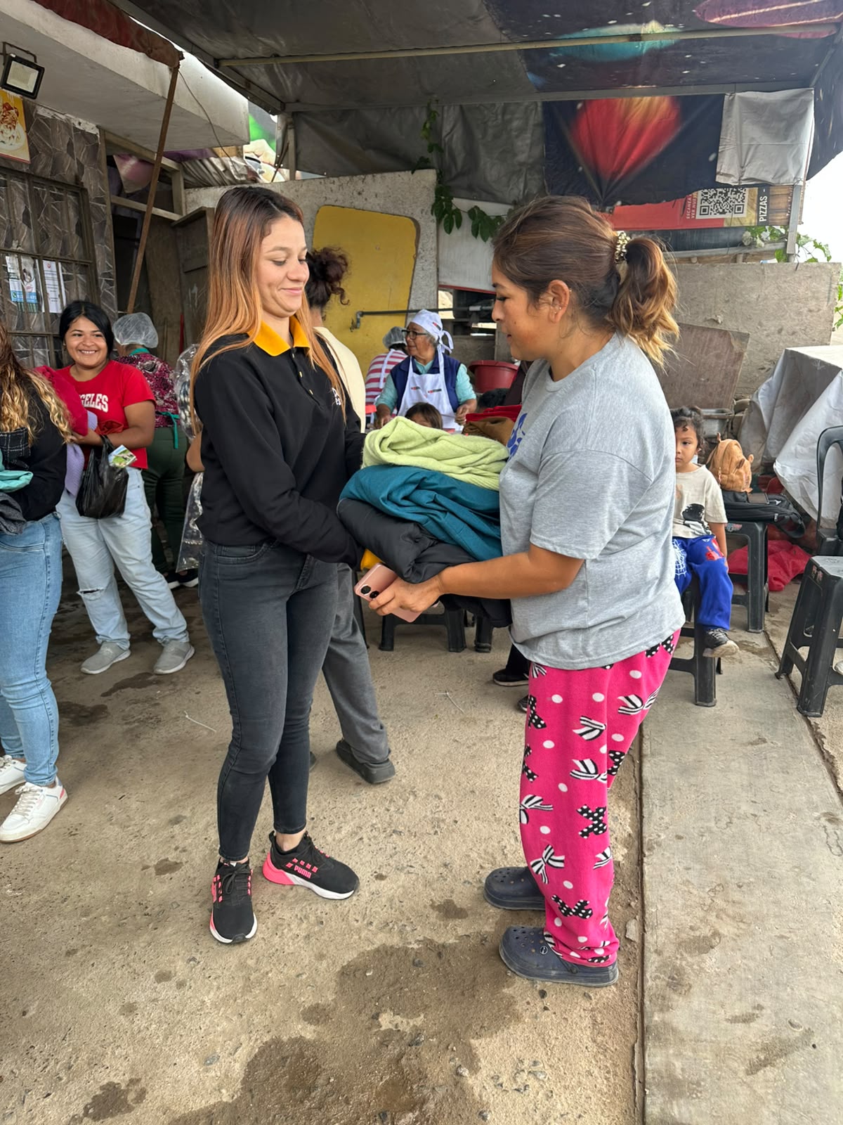Entrega de ropa donada a una persona de la comunidad