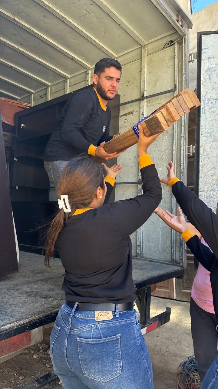 Voluntarios de Dar es Dar entregando un mueble a una familia